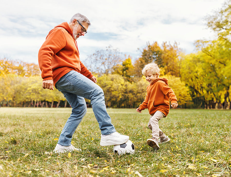 PBCo. Lifestyle Foods image of older man playing soccer with young child